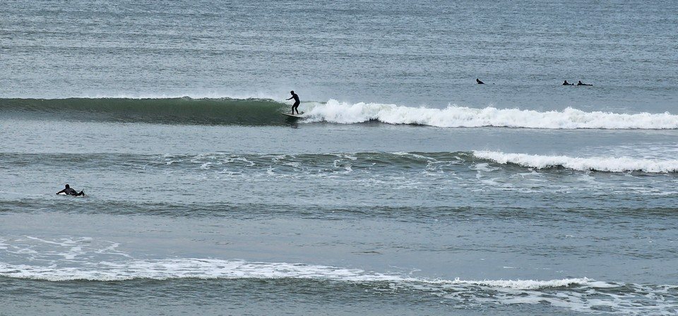 Surfer on a hip high wave in front of the shop